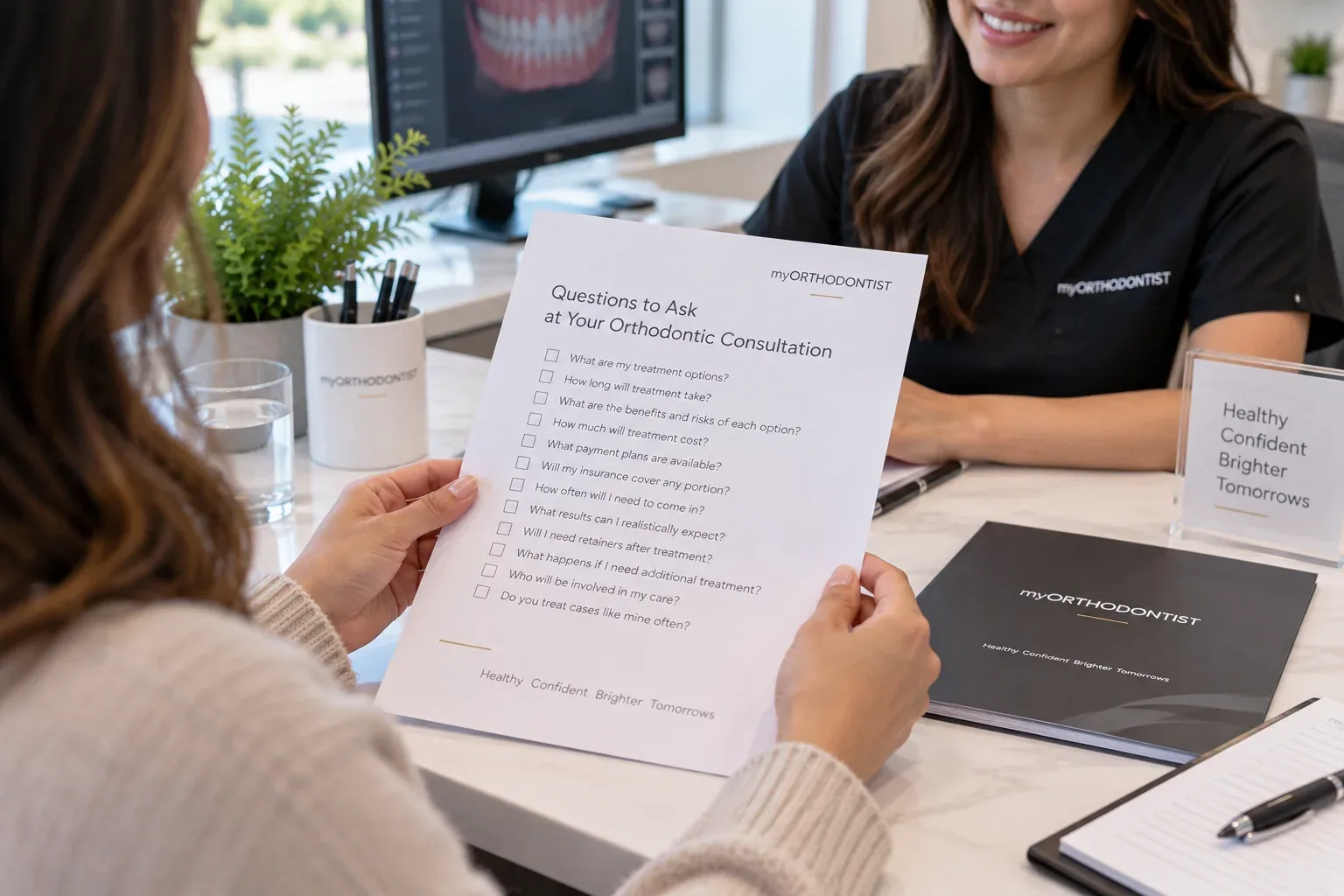 Parent holding a printed list of questions to ask at an orthodontic consultation