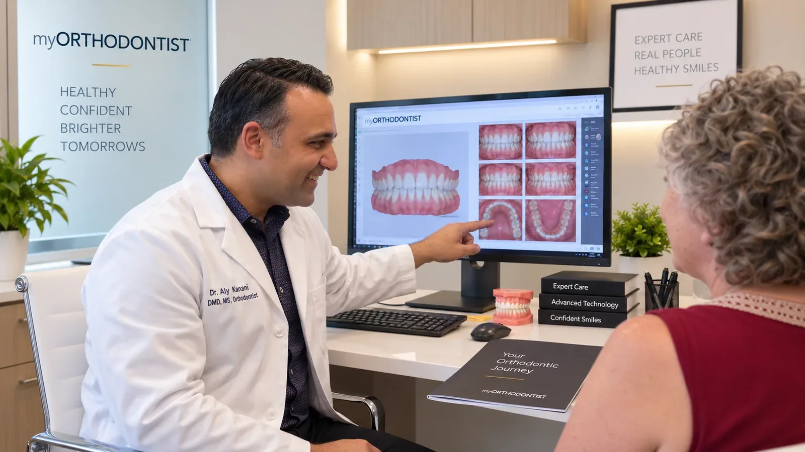 Dr. Aly Kanani reviewing orthodontic records with a patient during a consultation