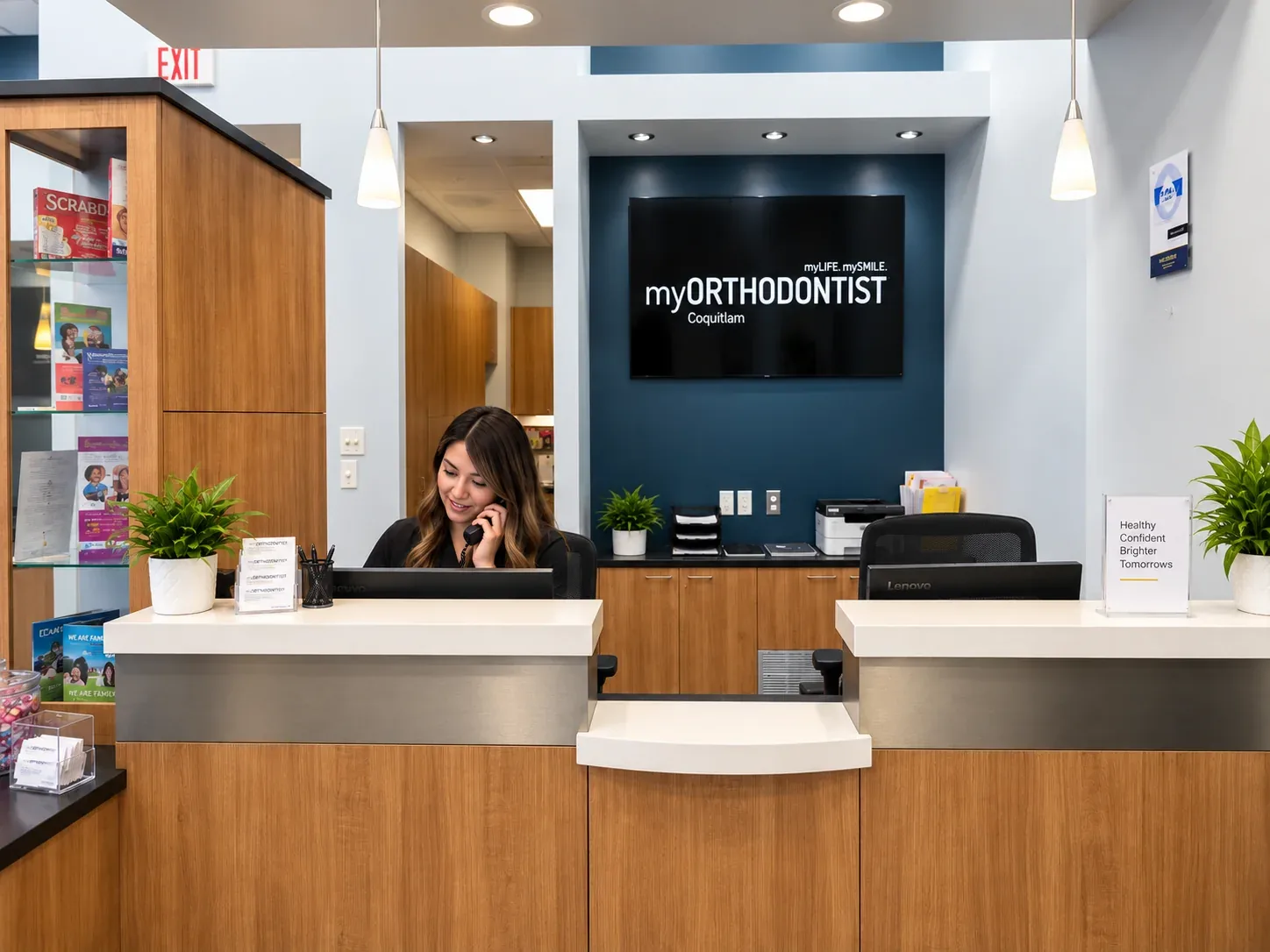 Reception coordinator speaking on the phone at the myORTHODONTIST Coquitlam front desk